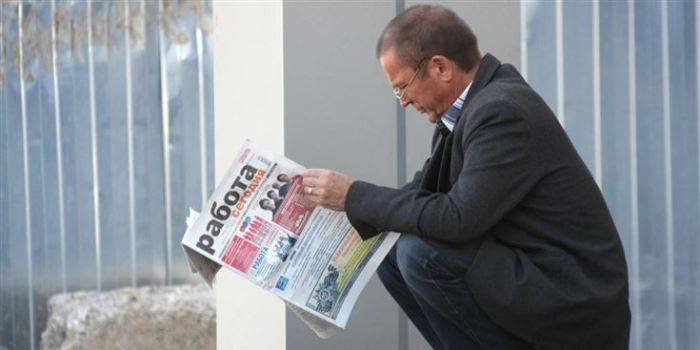 Мужчина читает газету о работе